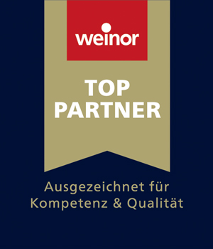 Die Anerkennung als weinor Top-Partner wird durch ein goldenes Banner symbolisiert. Dieser Banner weist oben einen roten Kasten mit dem Schriftzug „weinor“ in Weiß auf. In der Mitte des Banners steht ebenfalls in Weiß die Bezeichnung „TOP PARTNER“. Unterhalb des Banners im gleichen Goldton steht „Ausgezeichnet für Kompetenz & Qualität“.